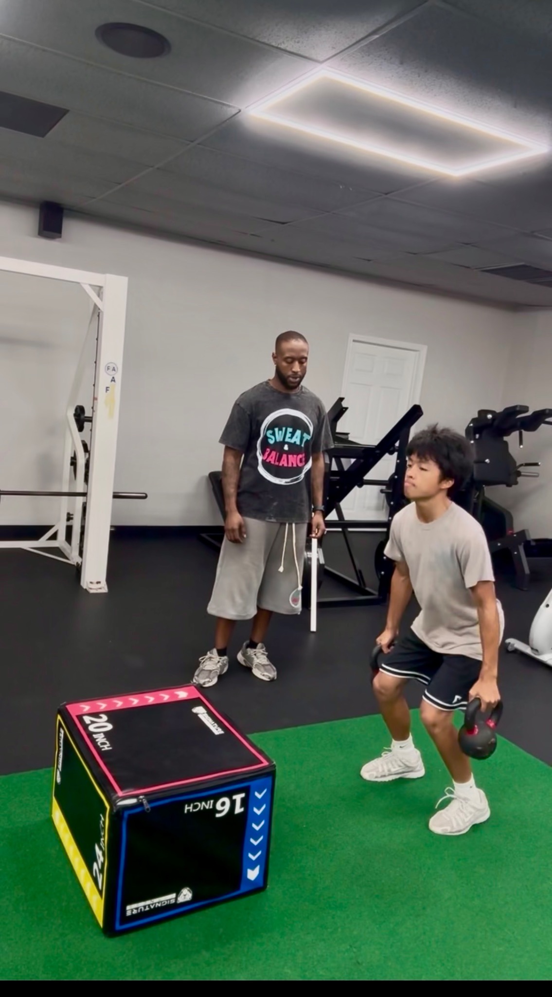 Coach Steph coaching kettlebell strength exercises for local clients